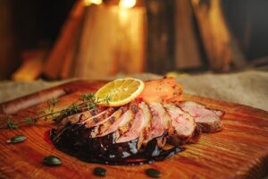 Cooked Duck with Cherry Sauce and Lemon slice garnish